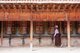 China: A pilgrim makes a circuit of the monastery turning each of the prayer wheels, Labrang Monastery, Xiahe, Gansu Province